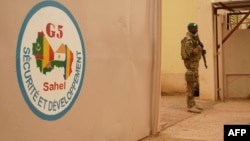Un soldat de l'armée malienne monte la garde devant le poste de commandement de la Force régionale d’Afrique de l'Ouest G5-Sahel, à Sevare, 30 mai 2018.
