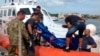 The body of a drowned migrant is being unloaded from a Coast Guard boat in the port of Lampedusa, Sicily, Oct. 3, 2013.