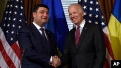 Wakil Presiden Joe Biden (kanan) berjabat tangan dengan PM Ukraina Volodymyr Groysman dalam pertemuan di Washington hari Rabu (15/6).
