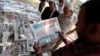 FILE - A man reads El-Watan newspaper at Tahrir square in Cairo, Egypt. 