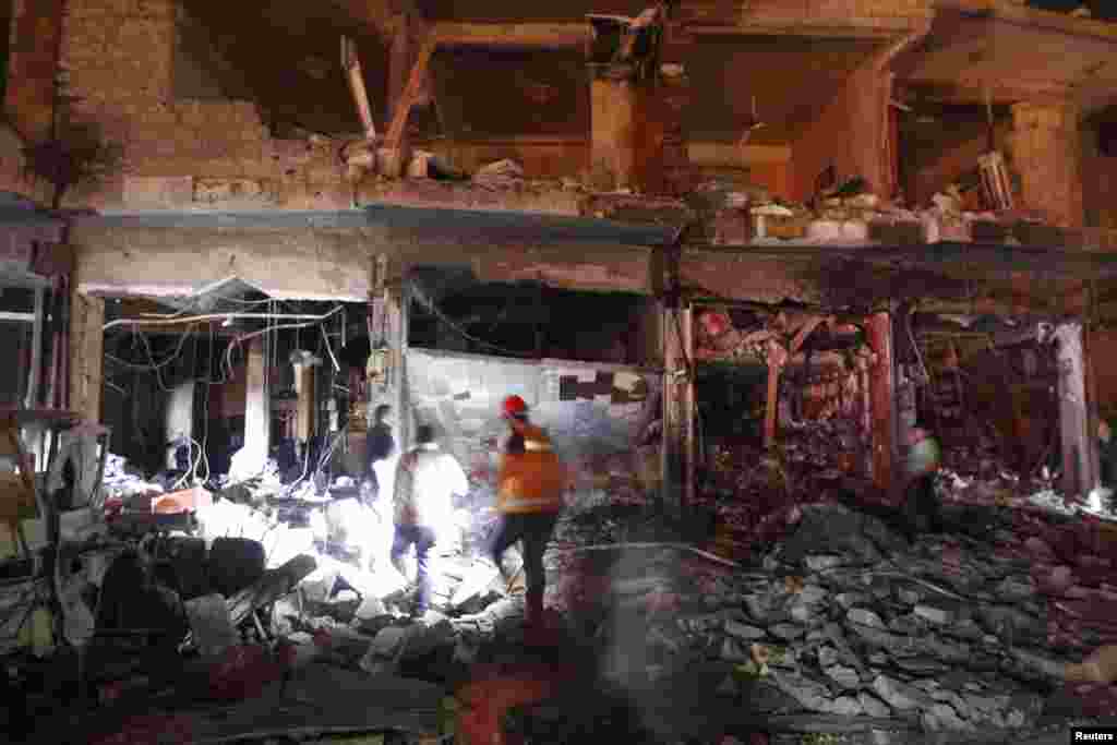 Civilians and rescuers search under rubble at a site hit by what activists say was a Scud missile from forces loyal to Syria's President Bashar al-Assad in Raqqa, Nov. 28, 2013.