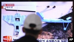4月2日一名男子在韩国首尔火车站收看有关无人机的电视报道（资料照片）