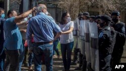 En la foto de archivo el periodista nicaragüense Carlos Fernando Chamorro, director de los medios de comunicación Confidencial y Esta Semana, es empujado por la policía antidisturbios frente a las oficinas de El Confidencial en Managua el 14 de diciembre de 2020.