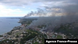 Smoke from burning buildings rise from Honiara on the Solomon Islands on Nov. 25, 2021, on the second day of rioting that left the capital ablaze and threatened to topple the Pacific nation's government. 