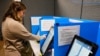 FILE - Courtney Parker votes on a new voting machine in Dallas, Georgia, Nov. 5, 2019,