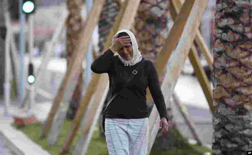 A woman cries asking for her son as she walk near the scene of an attack after a truck drove onto the sidewalk and plowed through a crowd of revelers who'd gathered to watch the fireworks in the French resort city of Nice, southern France, Friday, July 15