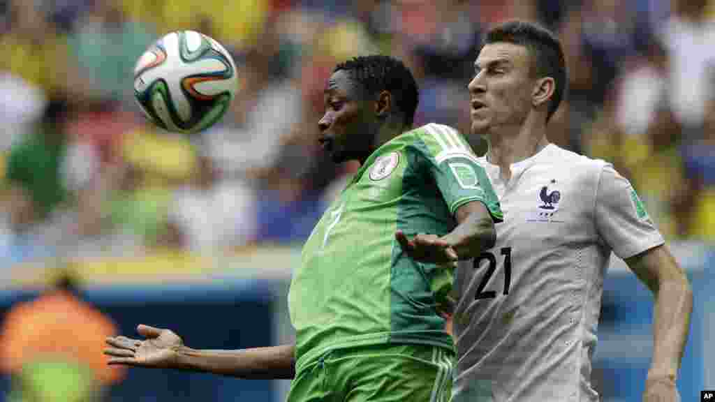 Ahmed Musa du Nigeria, à gauche, et Laurent Koscielny de la France se battent pour le ballon au cours du match de Coupe du Monde entre la France et le Nigeria au satde Nacional à Brasilia, au Brésil, le lundi 30 Juin 2014.