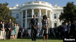 U.S. President Barack Obama and first lady Michelle Obama observe a moment of silence on the South Lawn of the White House to mark the 14th anniversary of the 9/11 attacks, in Washington September 11, 2015. Relatives of the nearly 3,000 people killed in t