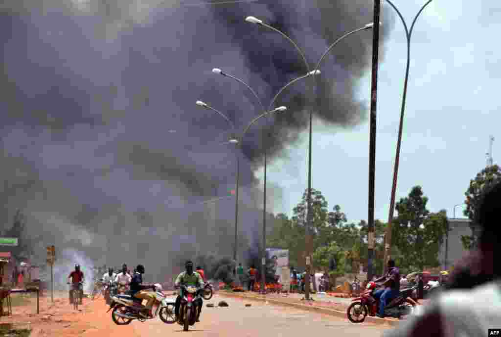 Residents burn tires along a street in Ouagadougou, Sept. 17, 2015, after Burkina Faso's presidential guard declared a coup, a day after seizing the interim president and senior government members, as the country geared up for its first elections since the overthrow of longtime leader Blaise Compaore. 
