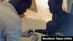 FILE - A health worker prepares to give medication intravenously to a child who has tested positive for malaria, in the Ayilo refugee resettlement camp in Uganda 