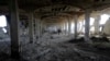 A Palestinian worker walks inside al-Awdah food factory, which witnesses said was shelled and torched by the Israeli army during the offensive, in Deirl al-Balah, central Gaza Strip, Aug. 14, 2014. 
