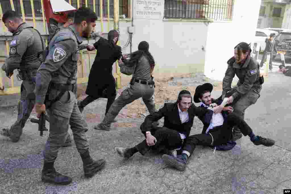 Members of the Israeli security personnel detain ultra-Orthodox protesters during a demonstration against conscription in Jerusalem. Historically exempt from compulsory military service, ultra-Orthodox seminary students are being called up amid Israel's war with Hamas and Hezbollah.