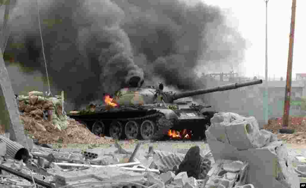 This citizen journalism image provided by The Syrian Revolution against Bashar Assad shows a Syrian military tank on fire during clashes with Free Syrian army fighters in Joubar, a suburb of Damascus, Sept. 18, 2013.