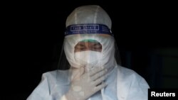 A volunteer wearing a protective suit adjusts his face mask before carrying a dead body amid the outbreak of the coronavirus disease (COVID-19), in Yangon, Myanmar, October 4, 2020. REUTERS/Shwe Paw Mya Tin