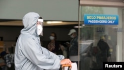 Un viajero que se dirige a Estados Unidos se protege con una máscara facial en el aeropuerto principal de Managua, Nicaragua, en mayo de 2020.