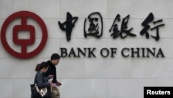 Seorang pejalan kaki melewati kantor cabang "Bank of China" di Beijing (Foto: dok). China diprediksi akan menjadi negara dengan ekonomi terkuat pada akhir 2014.