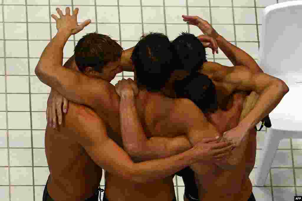 US swimmer Michael Phelps (C) reacts with teammates Brendan Hansen, Nathan Adrian and Matthew Grevers after they competed in the men's 4x100m medley relay final during the swimming event at the London 2012 Olympic Games on August 4, 2012 in London.