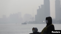 FILE - People wear protective masks during a polluted day in Shanghai, China, Jan. 19, 2016.