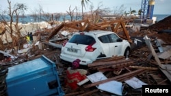 Uma mulher observa os destroços à volta das casas destruídas na sequência do ciclone Chido, em Mamoudzou, Mayotte.