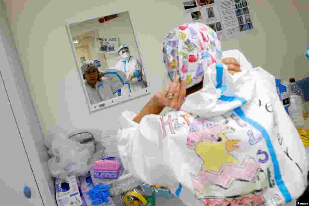 Una trabajadora médica que usa equipo de protección (EPP) decorado con dibujos con temas de Pascua se prepara antes de comenzar su turno en el hospital San Filippo Neri, en Roma, Italia, el 4 de abril. 2021.