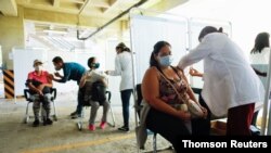 Las personas reciben su primera dosis de la vacuna rusa Sputnik V contra el coronavirus, en el estacionamiento del Instituto de Seguridad Social de las Fuerzas Armadas, convertido en centro de vacunación masivo, en Caracas. Junio 5, 2021. 