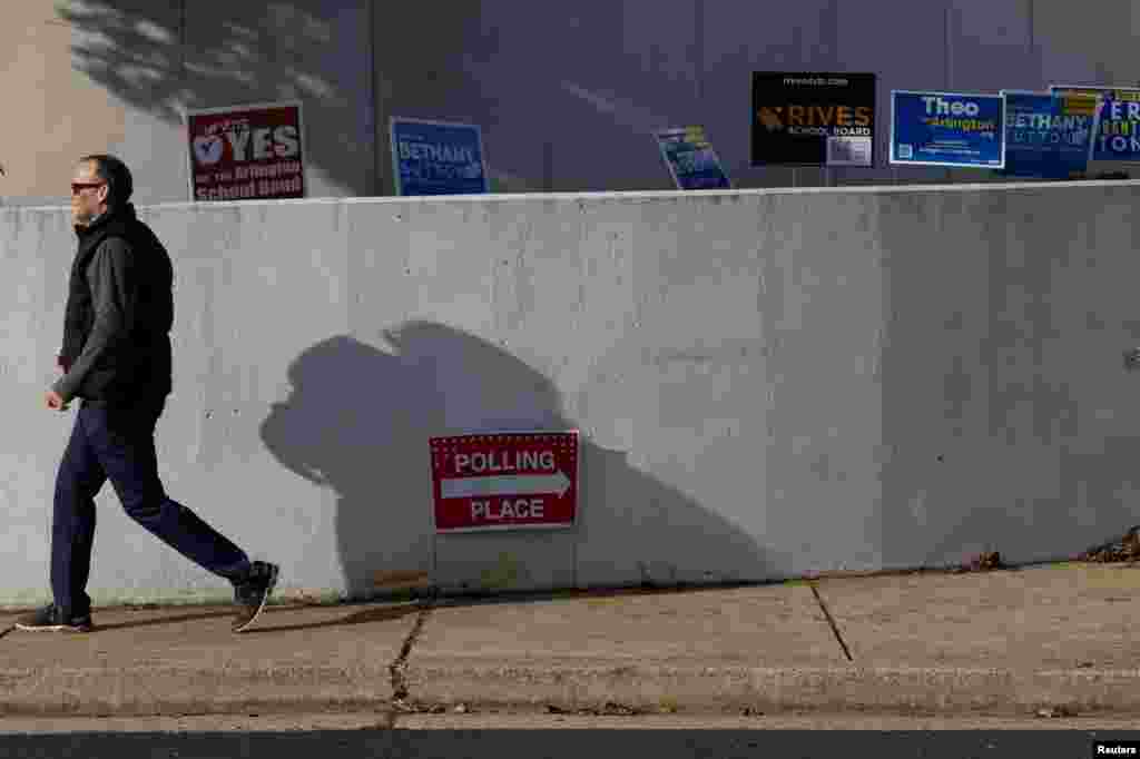 Un votante pasa por los carteles de la campaña fuera del edificio de la Junta Escolar del Condado de Arlington, Virginia, el 8 de noviembre de 2022. REUTERS/Tom Brenner