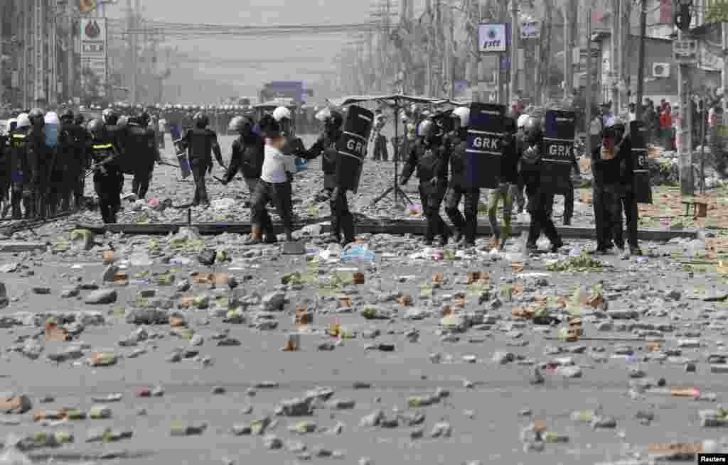 Workers are detained by riot police officers after clashes broke out during a protest in Phnom Penh, Jan. 3, 2014.