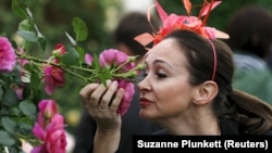 FILE - Paola Orsero of Alassio, Italy smells a rose at the Royal Horticultural Society's Chelsea Flower Show in London, Britain May 19, 2015. (REUTERS/Suzanne Plunkett)