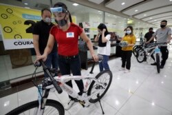 Benjamin Canlas Courage to be Kind Foundation founder Dr. George Canlas (left) watches as one of the winners pushes a bicycle during the award ceremony in Manila, Philippines, July 11, 2020.