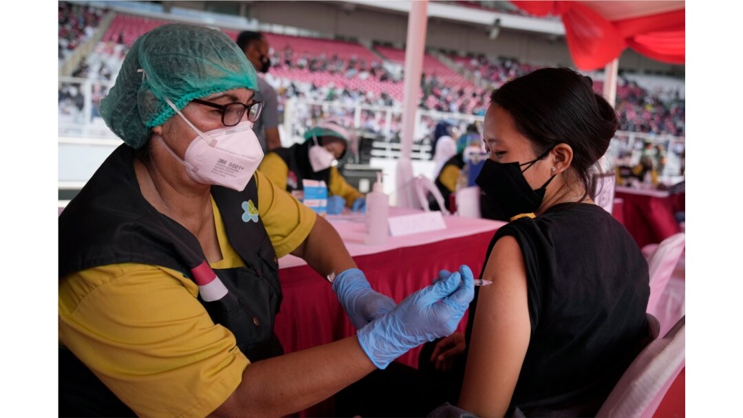 A woman receives a shot of the Sinovac COVID-19 vaccine during a mass vaccination at Gelora Bung Karno Main Stadium in Jakarta, Indonesia, June 26, 2021.