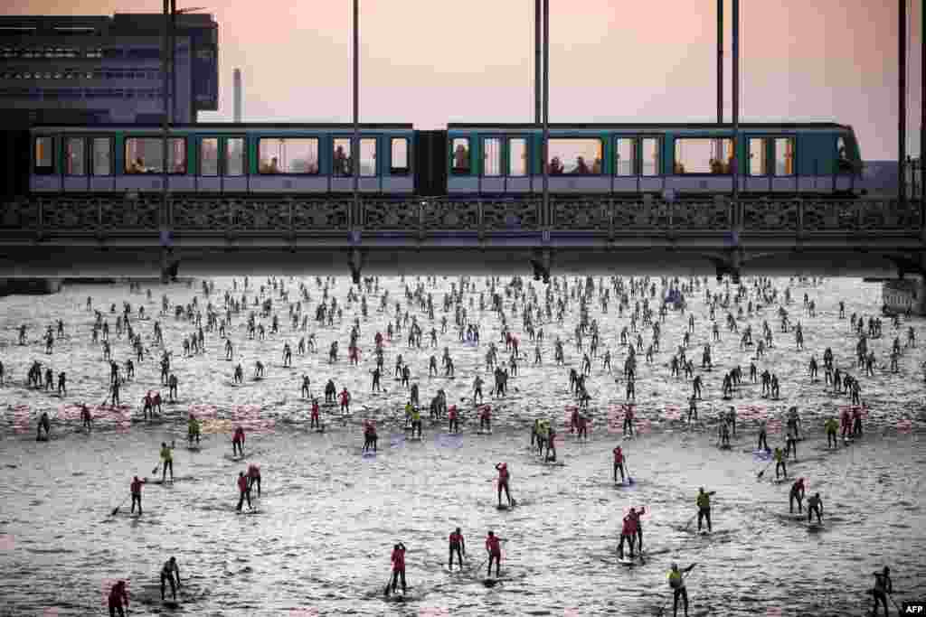Warga mengikuti lomba mendayung sambil berdiri di sungai Seine, Paris, Perancis.