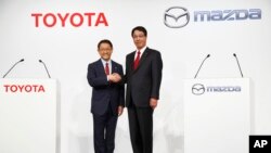 En esta foto de archivo vemos a presidente de Toyota Motor Corp. Akio Toyoda, (izquierda) y al presidente de Mazda Motor Corp. Masamichi Kogai, en Tokio, el 13 de mayo de 2015.
