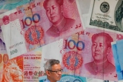 FILE - A man walks by an exchange shop decorated with Chinese yuan in Hong Kong, Aug. 6, 2019. China let the yuan sink to an 11-year low against the dollar after President Donald Trump threatened to block U.S. firms from doing business with China.