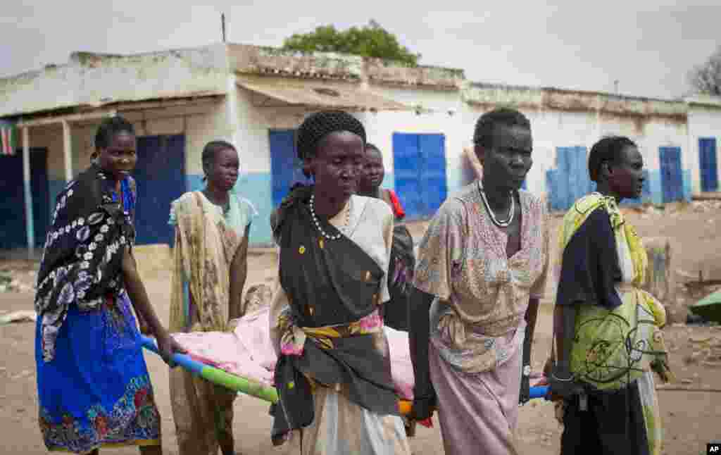 Women carry the body of a civilian killed in the center of Malakal, Upper Nile State in South Sudan, Jan. 21, 2014.