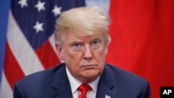 President Donald Trump listens to Japan's Prime Minister Shinzo Abe speak during their meeting, Nov. 30, 2018 in Buenos Aires, Argentina. 