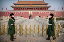 Paramilitary police wear face masks as they stand guard at Tiananmen Gate adjacent to Tiananmen Square in Beijing, Jan. 27, 2020.