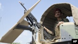 FILE - An Afghan National Army soldier stands guard in his vehicle in Camp Khogyani in Nangarhar province, east of Kabul — a region where homegrown militants loyal to the Islamic State group have made some inroads, Aug. 5, 2015.