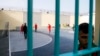 Des détenus de la prison d'Oukacha aperçus depuis une grille lors d’un mini tournoi de football organisé par des prisonniers africains pour coïncider avec la compétition CHAN-2018, à Casablanca, Maroc, 1er février 2018.