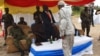 New president of the M23 rebel movement, Bertrand Bisimwa (in orange tie) shakes hands with M23 military commander Sultani Makenga, in Bunagana in eastern DRC, March 7, 2013. (N. Long/VOA)