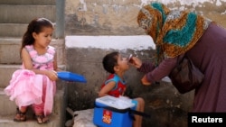 Seorang petugas medis memberikan vaksinasi polio kepada anak-anak dari rumah ke rumah di Pakistan (foto: ilustrasi). 