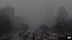 Antrian panjang kendaraan terlihat di jalanan Beijing diantara gedung-gedung pencakar langit yang tertutup asap polusi (Foto: dok). Sebagian ilmuwan mengatakan kegiatan manusia dan polusi dari mobil dan pabrik juga ikut berperan dalam memanasnya suhu Bumi.
