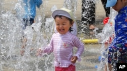 Anak-anak bermain air untuk menyegarkan diri di sebuah taman di Yokohama, dekat Tokyo, 18 Agustus 2020. (Foto: Koji Sasahara/AP Photo)