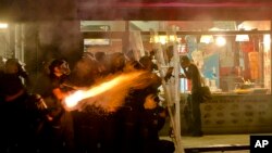 Polisi anti huru hara Turki menembakkan gas air mata setelah memburu para pemrotes keluar dari Taman Gezi di Istanbul (15/6). (AP/Vadim Ghirda)