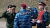 A photo provided by the Russian Defense Ministry shows Russian Defense Minister Sergei Shoigu (L) awarding a former Ukrainian special forces "Berkut" officer (back to camera) at a military base in Sevastopol, Crimea, March 24, 2014.