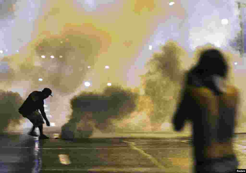 Huquq-tartibot xodimlari ko'chalarni nazorat ostiga olishga urinmoqda, Ferguson, 17-avgust, 2014-yil.