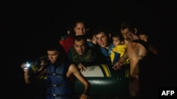 Un grupo de migrantes son arrastrados a través del Río Grande por traficantes de personas mientras cruzan la frontera entre Estados Unidos y México en balsas en Roma, Texas, el 8 de julio de 2021.