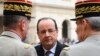 France's President Francois Hollande (C) speaks to military officials as he attends a ceremony to the memory of Stephane Hessel, at the Invalides in Paris, March 7, 2013.