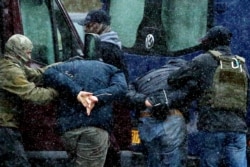 Law enforcement officers detain two men as opposition supporters protest against police violence and the August 9, 2020 Belarus presidential election results in Minsk, Belarus on November 29, 2020.