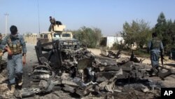 Pasukan keamanan Afghanistan memeriksa lokasi serangan udara di Kunduz, utara Kabul, Afghanistan (2/10).