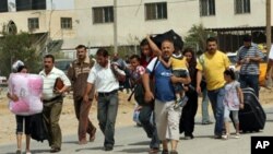 Palestinians carry their belongings as they head towards the newly-opened border crossing to Egypt in Rafah, in the southern Gaza Strip, 01 Jun, 2010